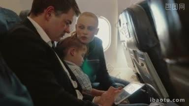 年轻的父母和小儿子在飞机上玩手机